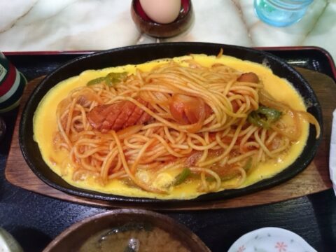 ナプキンに包まれたフォークと粉チーズとタバスコ