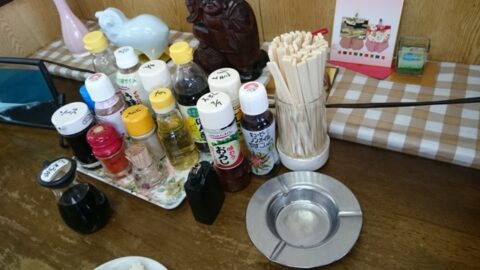 調味料と灰皿のある魚一食堂のテーブル
