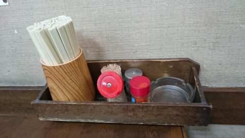 調味料と灰皿のある長命うどんのテーブル