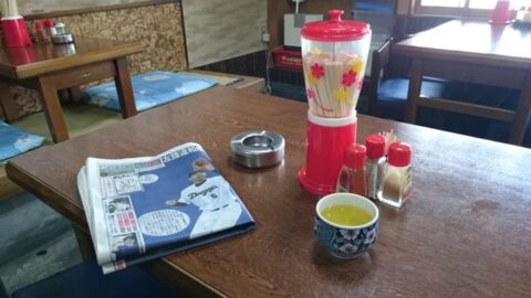 調味料とスポーツ新聞のある玉の家のテーブル