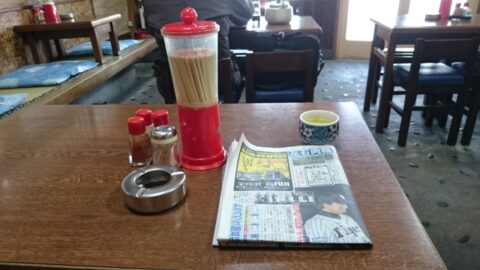 調味料とスポーツ新聞のある玉の家のテーブル