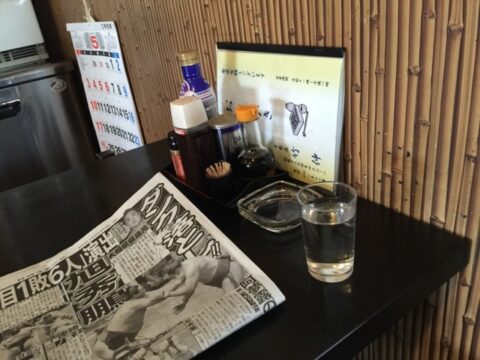 灰皿とスポーツ新聞のある竹仲の席