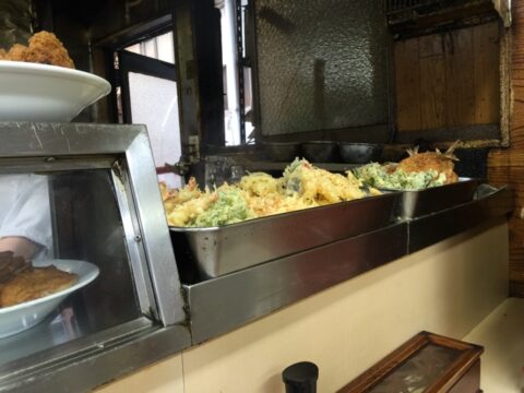 カウンターに並ぶ揚げ物と惣菜