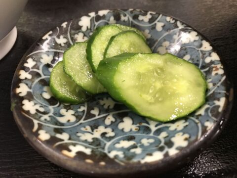 色の濃い汁に白い刻み葱とわかめが浮かぶかけそば