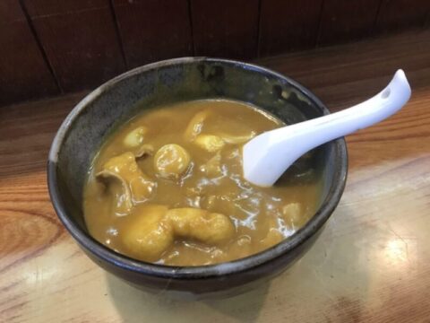 本店鯱乃家のカレーうどん。とろみのあるカレーのつゆに油揚げが浮かぶ