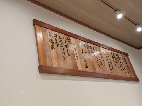 壁掛けのドリンクメニュー板。ビール・ハイボール・レモンサワーなど。