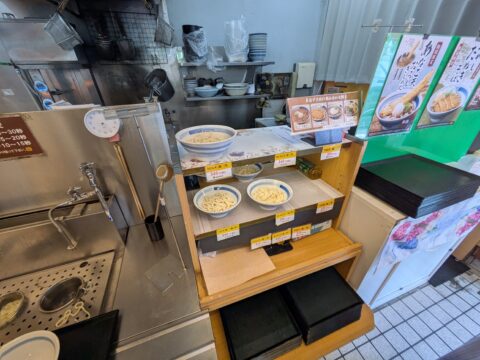 どんどん庵の店内｜入店すると麺の丼が棚に並び、自分で湯切りできるテボが設置されている