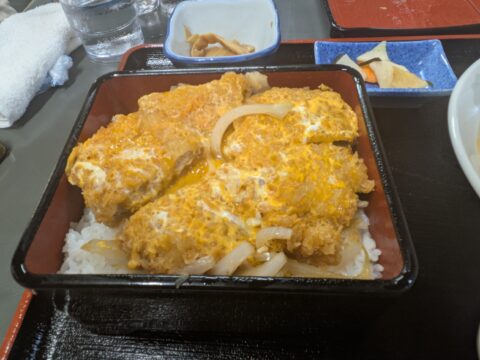 相川食堂のカツ丼｜卵でとじたカツがご飯を覆う、蓋を開けた瞬間のビジュアル