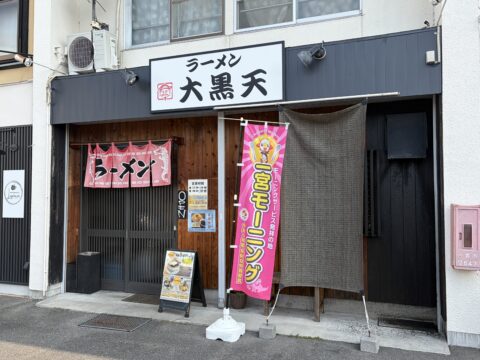 ラーメン大黒天の外観。ピンクの「一宮モーニング」の幟と雷文模様のラーメン暖簾