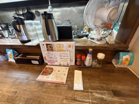 大黒天のカウンター席。卓上メニューや調味料が並び、奥に厨房が見える