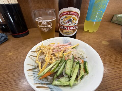 魚源食堂の中華春雨サラダとキリンラガーの大瓶ビール。春雨に錦糸卵、ハム、きゅうり