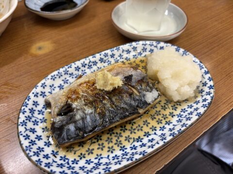 魚源食堂の鯖の塩焼き。大将が七輪で焼き上げた一皿に大根おろしと三杯酢