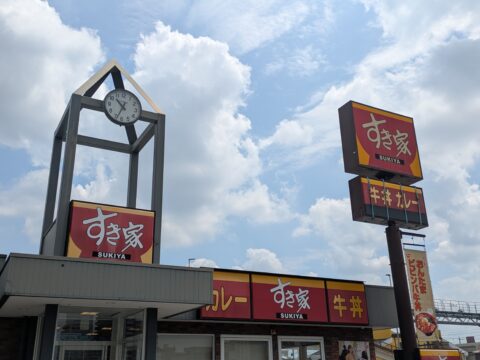 すき家の店舗外観｜青空に牛丼・カレーの看板と時計塔