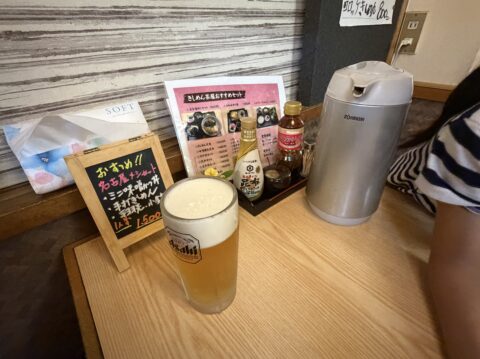 角千本店きしめん茶屋の卓上。生ビールとおすすめの黒板、調味料が並ぶ