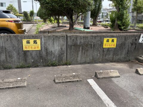 桜鮨の専用駐車場。黄色い「桜鮨 専用駐車場」の看板が掲げられている