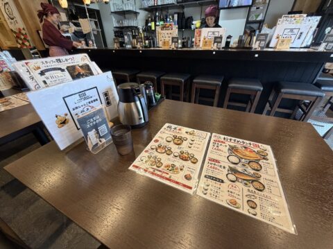 龍虎朱の店内のテーブル席とメニュー表、QRコード注文の案内