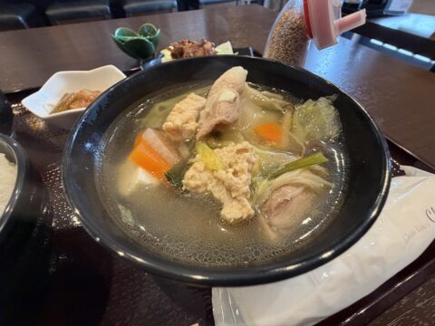 龍虎朱のちゃんこ鍋のアップ。澄んだスープに鶏肉、つみれ、白菜、人参、葱