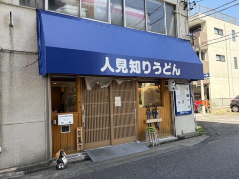人見知りうどんの外観。青いテントに白文字で「人見知りうどん」