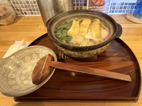 人見知りうどんの鍋焼きうどん。土鍋で提供され、卵焼きやかまぼこが乗る