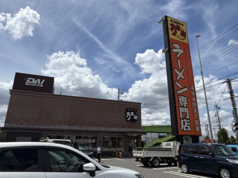 うま屋本店の外観。「ラーメン専門店」の縦看板と、隣接する運営会社の社屋
