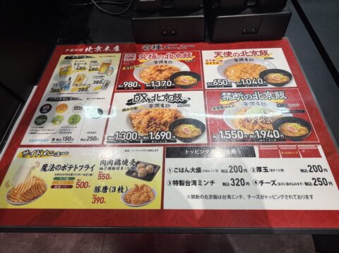 卓上のメニュー表。究極・天使・DX・禁断の北京飯とトッピングの価格