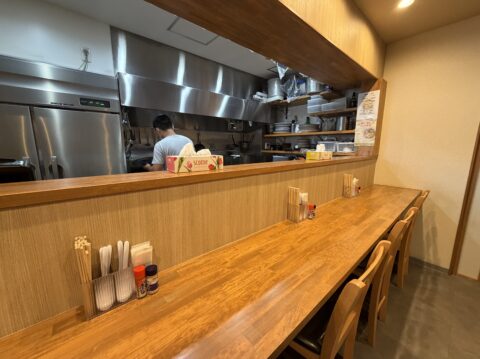 店内のカウンター席と厨房。スタッフが仕込みをしている