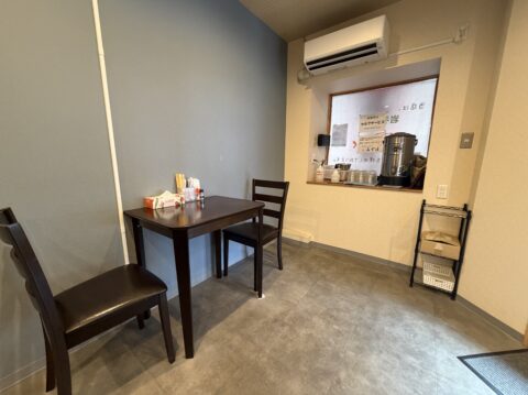 店内奥のテーブル席。烏龍茶のサーバーが置かれている