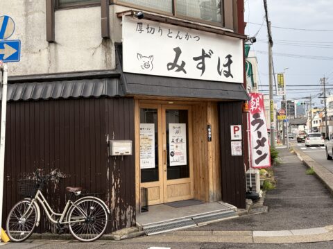 厚切りとんかつみずほの外観。豚のロゴの看板と朝中華そばの幟