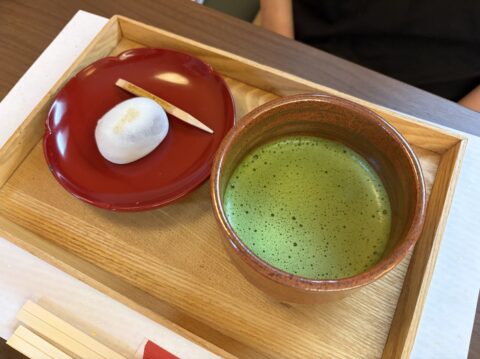 喜与女茶寮の抹茶ときよめ餅のセット。朱色の皿に焼き印入りの純白の餅