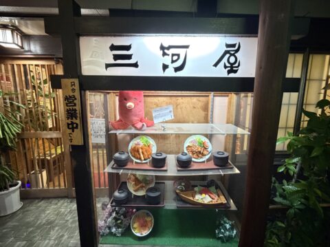 御食事処三河屋の食品サンプルのショーケースと「只今営業中です」の札（夜）