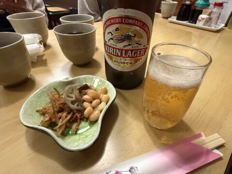 三河屋のキリンラガー大瓶とお通し（きんぴら、れんこんと大豆の煮物）