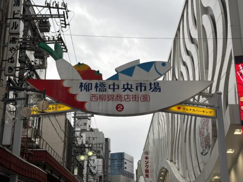 柳橋中央市場のアーチ看板。魚とエビの装飾に「柳橋中央市場 西柳錦商店街」の文字