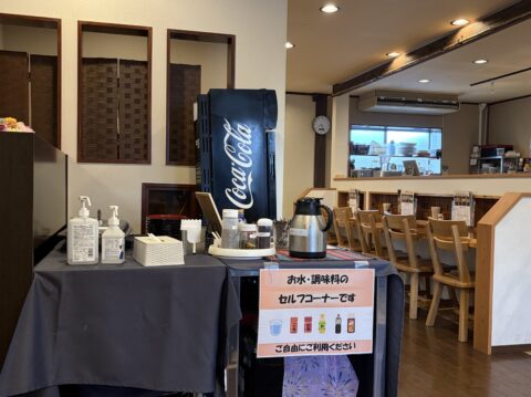 野武士の店内。お水と調味料のセルフコーナー、奥にカウンター席
