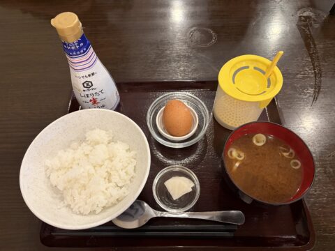 野武士の卵かけご飯セット。生卵、ご飯、味噌汁、漬物、しぼりたて生醤油、黄色いメレンゲ泡立て器
