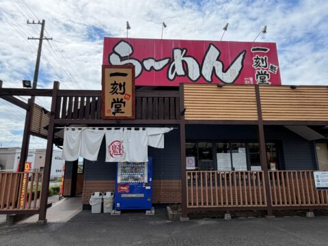 一刻魁堂の外観。赤い大看板に「ら~めん 一刻魁堂」、入口に白い暖簾