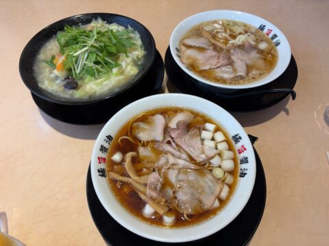 テーブルに並んだ三杯。手前に濃厚ブラック、奥に一刻しょうゆとアサリ入り塩野菜タンメン