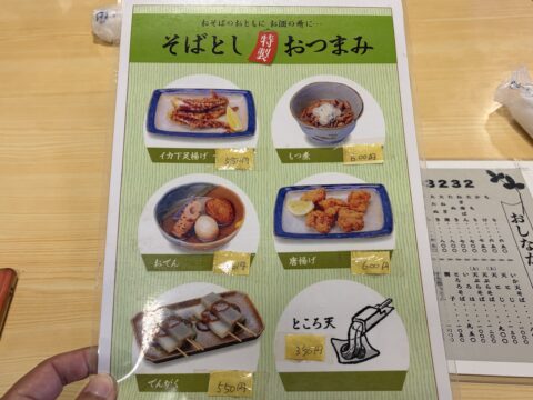 そばとし特製おつまみのメニュー。イカゲソ揚げ、もつ煮、おでん、唐揚げ、こんにゃく田楽、ところ天
