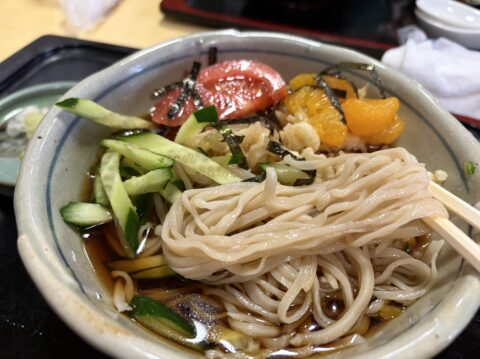 冷やしたぬきのそばを箸で手繰る