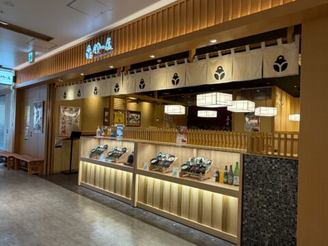 鈴の屋 ミュープラット神宮前店の外観。白い暖簾と料理見本