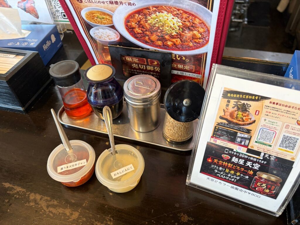 麺屋天空の卓上。激うま天空辛ジャンとおろしにんにく、天空どろラー油800円