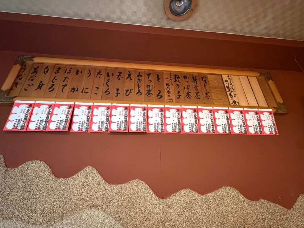 木札のお品書きと、大相撲七月場所の大入袋